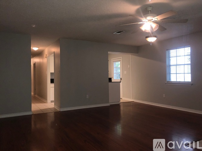 A room with a ceiling fan and a window.