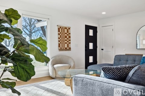 A living room with a grey couch and a glass table.