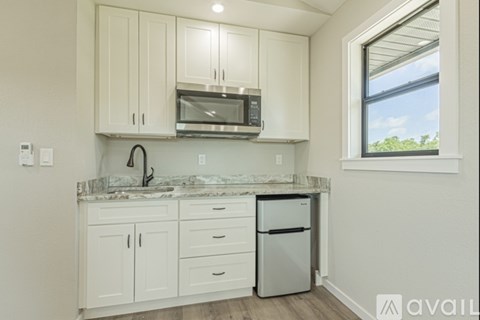 A kitchen with white cabinets and a stainless steel dishwasher.