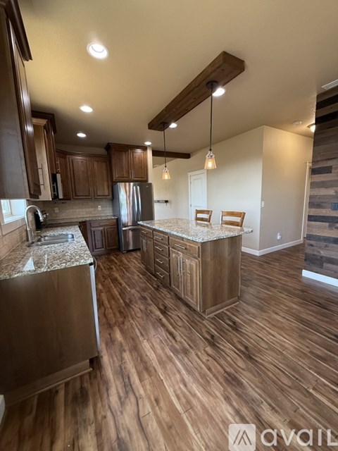 A kitchen with wooden floors and cabinets.