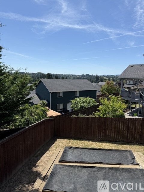 A backyard with a hot tub and a view of the neighborhood.