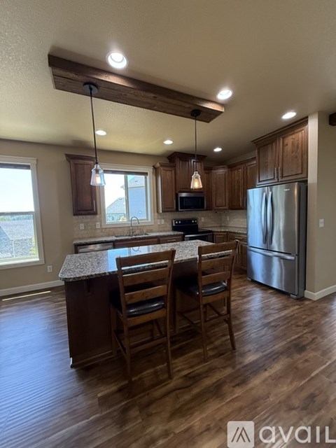 A kitchen with wooden cabinets and a granite countertop.
