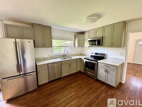 A kitchen with wooden floors and stainless steel appliances.