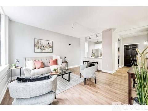 A living room with a grey couch and a white sofa.