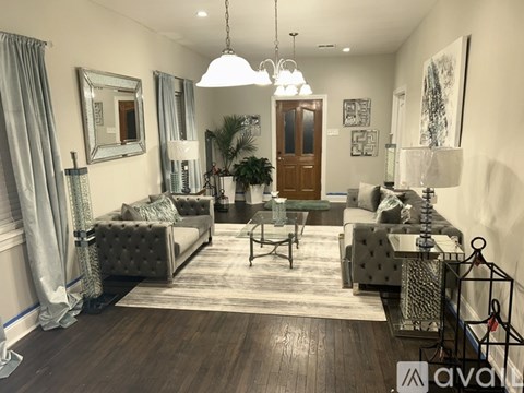 A living room with a grey sofa set and a wooden floor.