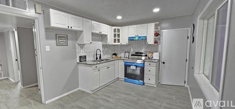 A kitchen with a blue oven and white cabinets.