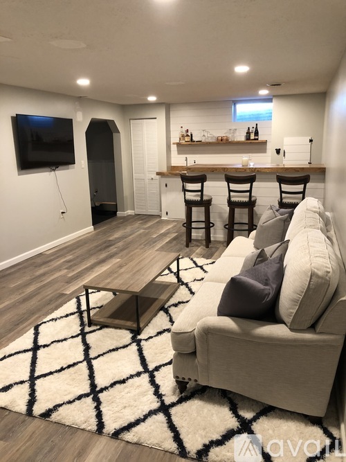A living room with a grey couch and a black and white rug.