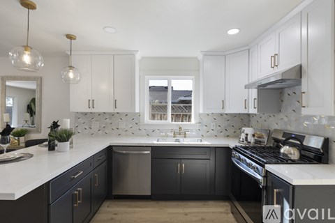 A modern kitchen with dark cabinets and a white countertop.