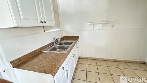 A kitchen with white cabinets and a brown countertop.