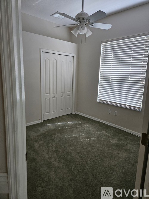 A room with a ceiling fan and a closed door.