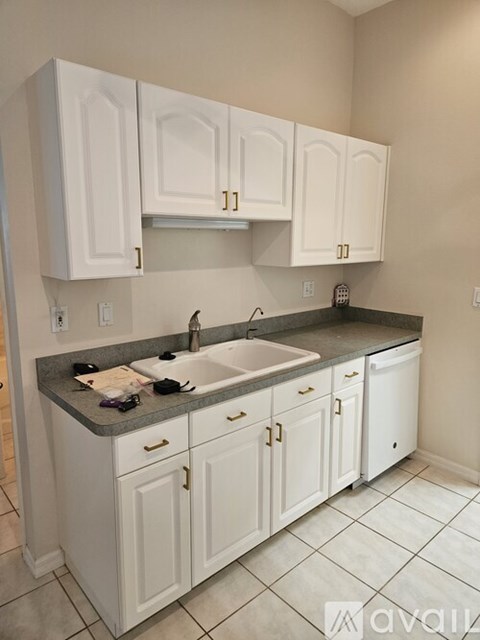 A kitchen with white cabinets and a sink.