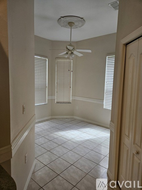 A room with a ceiling fan and tiled floor.