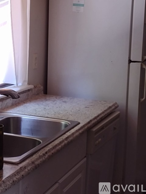 A kitchen with a sink and a refrigerator.