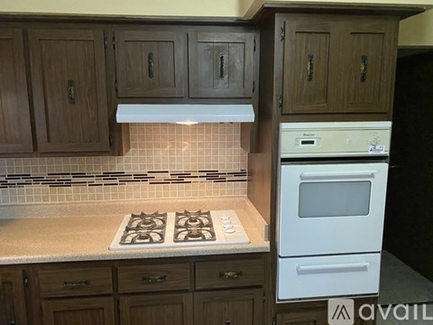 A kitchen with a white oven and a tiled backsplash.