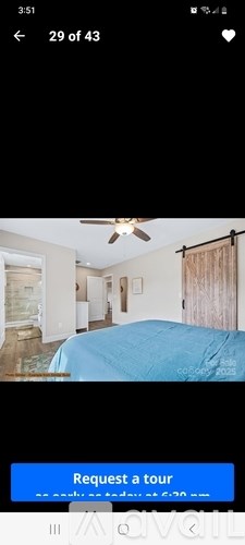 A bedroom with a bed covered in a blue bedspread.