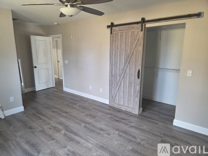 A room with a sliding door and a ceiling fan.