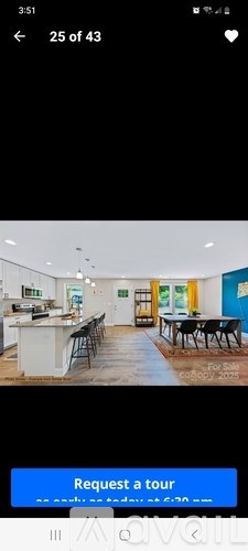 A room with a kitchen area and a dining table.