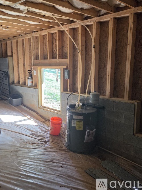 A bedroom with a bed, a ceiling fan, and a window with curtains.