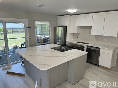 A kitchen with a white countertop and cabinets is available for rent.