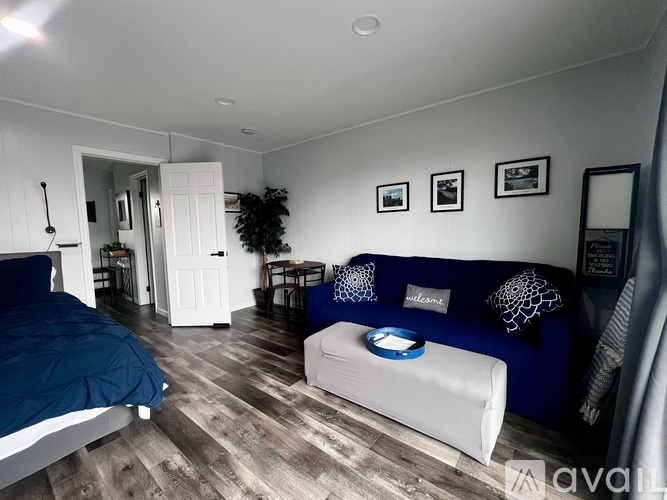 A bedroom with a bed, a couch, and a plant.