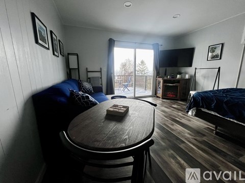 A living room with a blue couch and a wooden table.