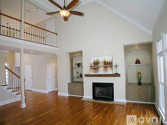 A living room with a fireplace and a ceiling fan.