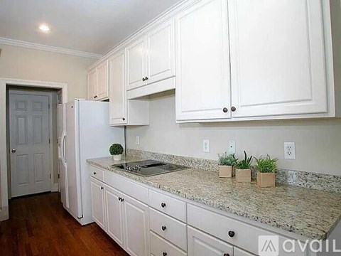 A kitchen with white cabinets and a granite countertop.