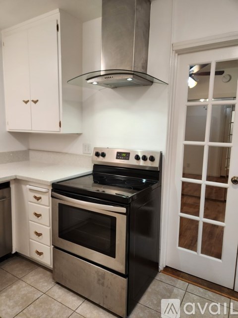 A modern kitchen with a stove top oven, microwave, and a range hood.