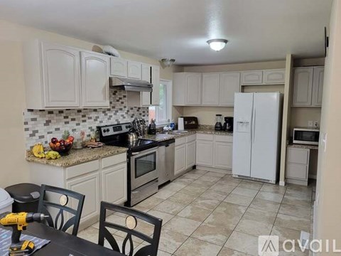 A kitchen with white cabinets and a black table.