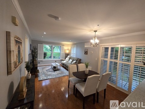 A well-lit living room with a dining table and chairs.