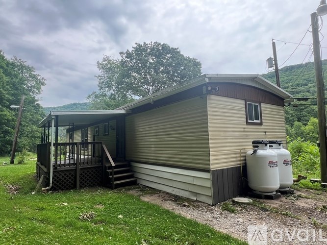 A small house with a porch and a metal roof.