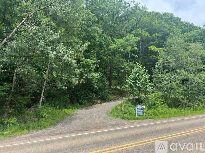 A house with a brown roof and a white wall is shown from an aerial perspective.