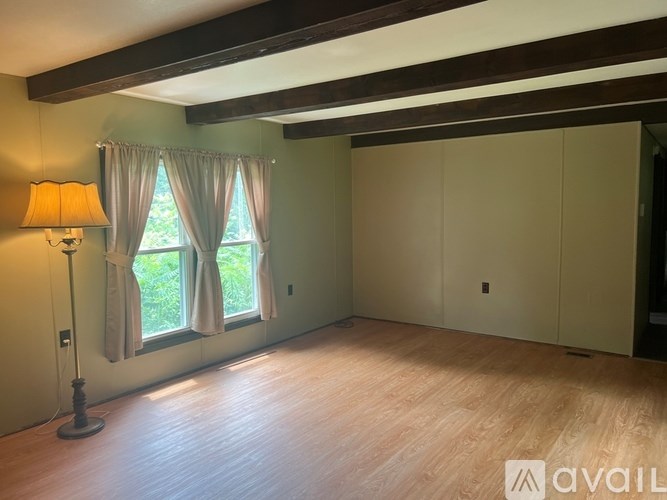A kitchen with a white stove, refrigerator, and wooden cabinets.