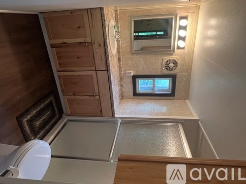 A bathroom with a toilet, sink, and a small TV mounted on the wall.