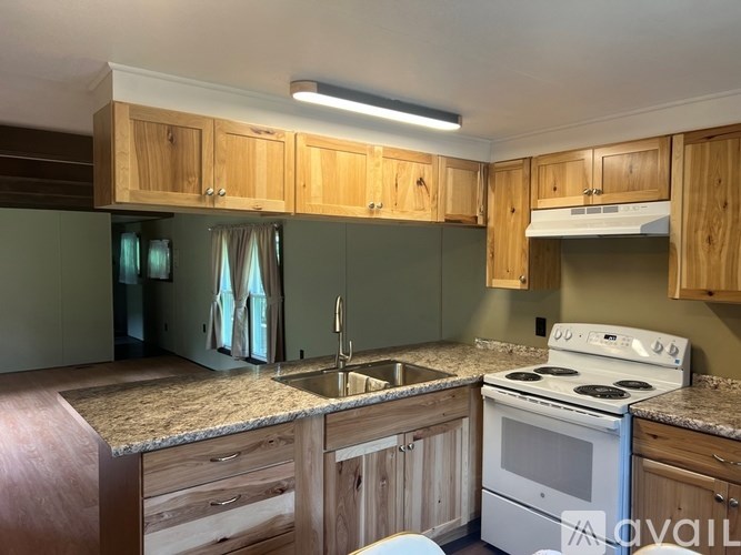A white toilet with a wooden cabinet above it.