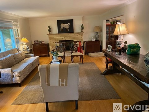A living room with a fireplace and a chair with the letter H on it.