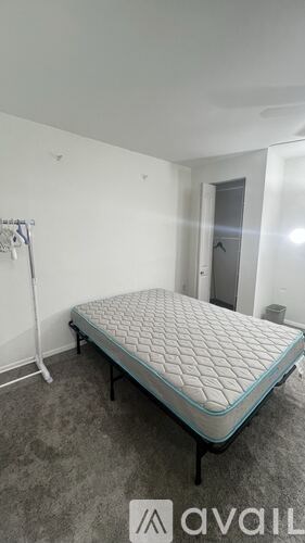 A mattress is available for rent in a room with white walls.