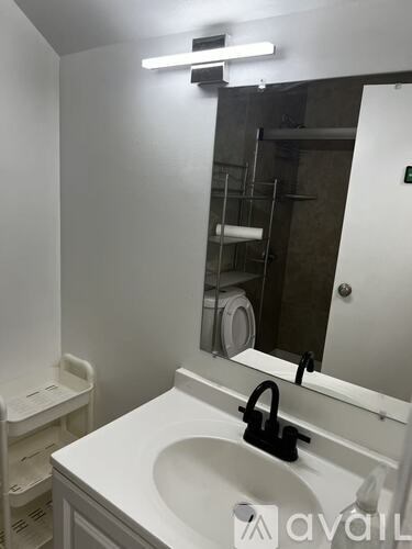 A white sink in a bathroom with a mirror above it.