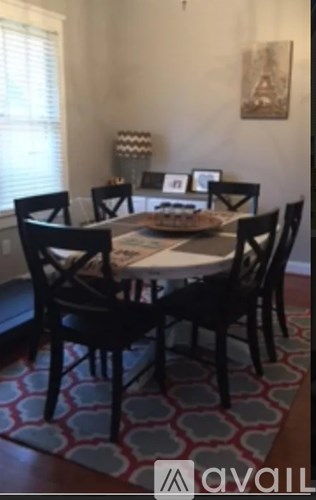 A dining room with a table and chairs.