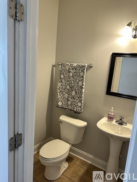 A room with a bed, a door, and a wall hanging.