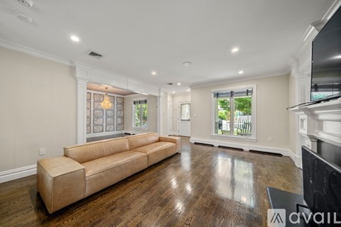 A spacious living room with a long beige sofa and a television.