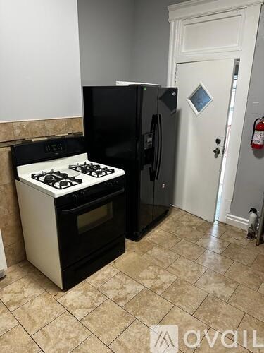 A black and white stove and refrigerator in a kitchen.