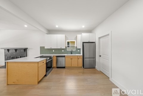 A modern kitchen with wooden cabinets and black appliances.