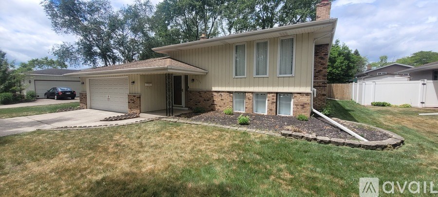 A house with a garage and a driveway in front of it.