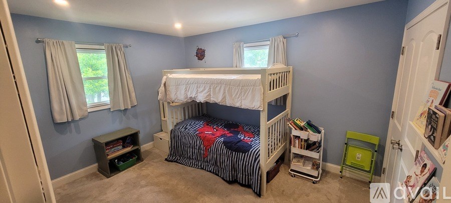 A bedroom with a bunk bed and a window with curtains.