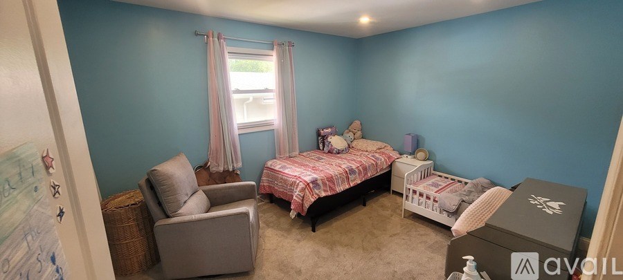 A room with two beds and a chair.