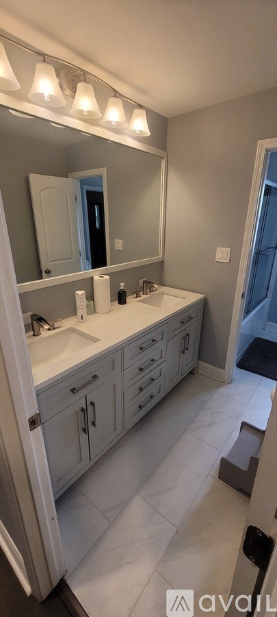 A bathroom with a white counter and a large mirror.