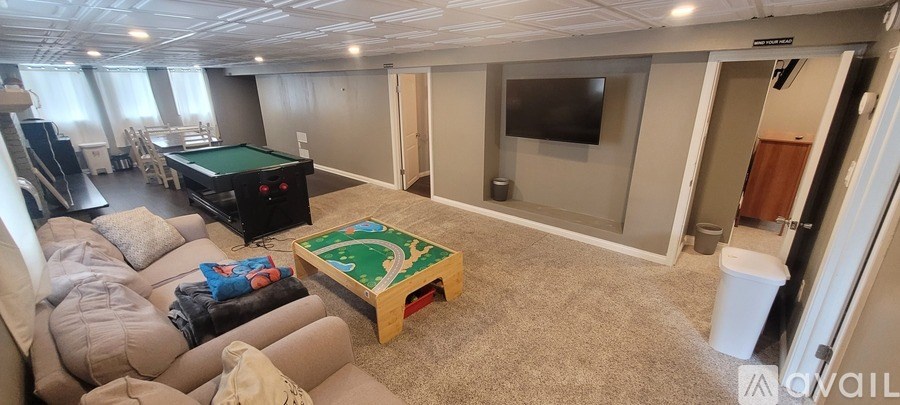 A living room with a pool table and a couch.