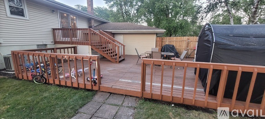 A deck with a bicycle and a grill on it.