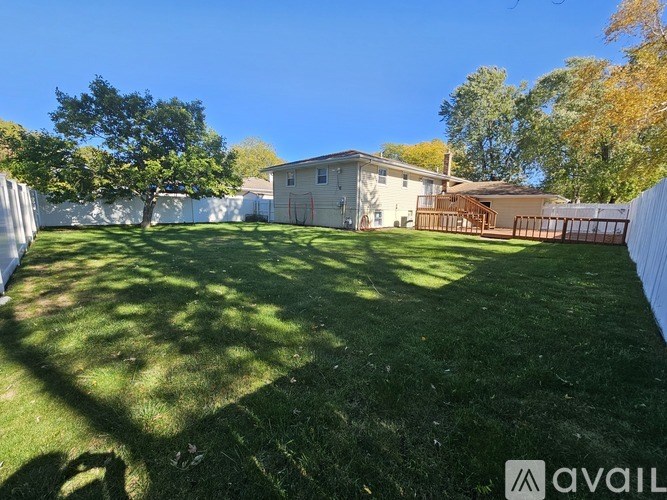 A backyard with a lawn and a house in the background.